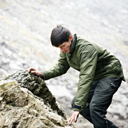 Person in a green jacket climbing rocky terrain in a Buffalo Mountain Shirt