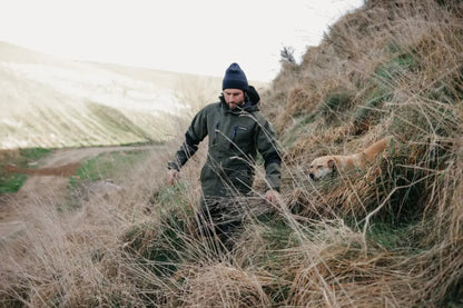 Man in Bushbuck Defender Waterproof Jacket outdoors with dog for country clothing or hunting