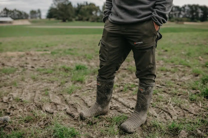 Person wearing dark Bushbuck Venture Pants 2.0 and rubber boots outdoors