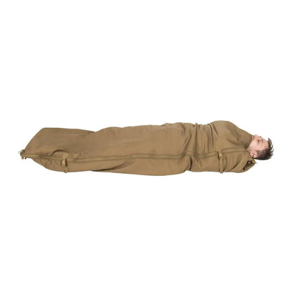 Person inside Helikon-Tex Swagman Roll poncho sleeping bag, zipped up cozy for camping