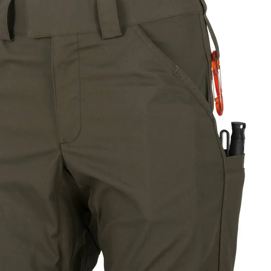 Olive green Helikon-Tex Woodsman Pants designed for outdoor enthusiasts with pockets and carabiner
