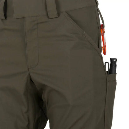 Olive green Helikon-Tex Woodsman Pants designed for outdoor enthusiasts with pockets and carabiner