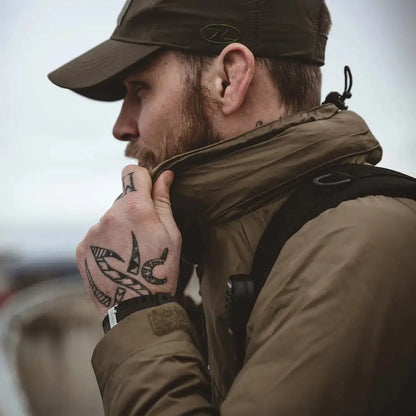 Man with hand tattoos rocking a cap and jacket in Highlander Halo Smock