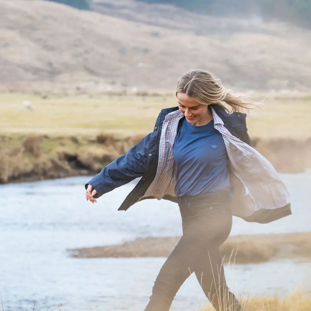 Woman wearing a navy Hoggs of Fife Fara Waterproof Jacket perfect for rainy days