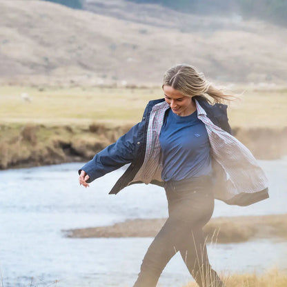 Woman wearing a navy Hoggs of Fife Fara Waterproof Jacket perfect for rainy days