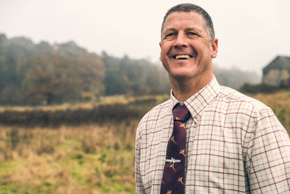 Smiling man wearing a Jack Pyke Pheasant Tie, Hanky & Cufflinks Set with style