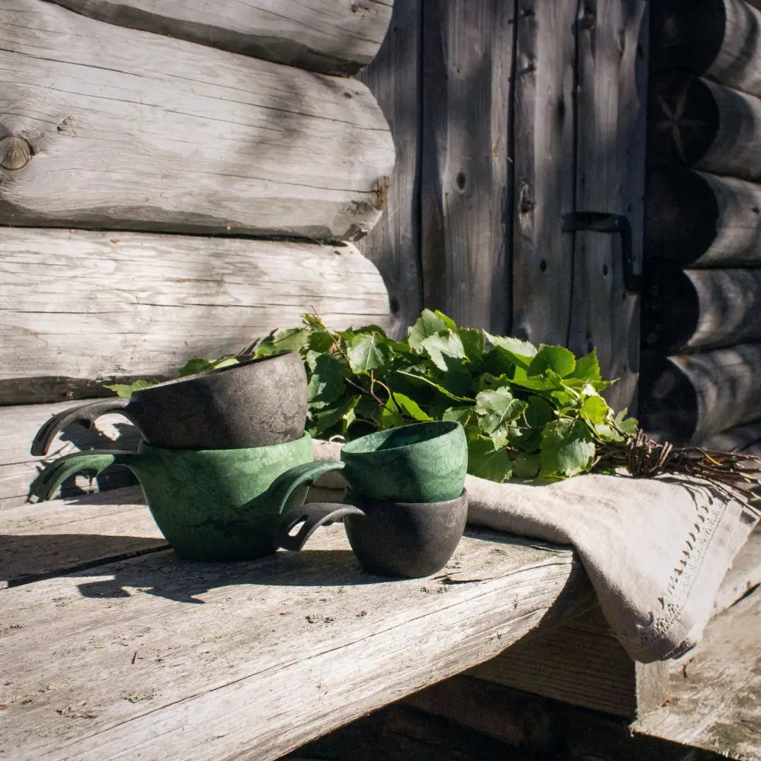 Stacked rustic Kupilka Large Cups with birch branches, perfect for outdoors and hunting vibes