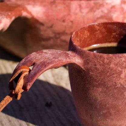 Reddish-brown Kupilka Shot Cup with leather strap, perfect for outdoor adventures