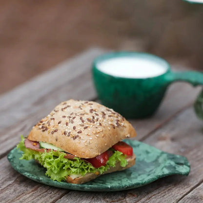 Seeded bun sandwich on Kupilka Small Plate, perfect for country clothing adventures outdoors