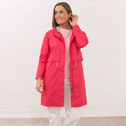 Woman wearing a Lighthouse Ladies Pippa Coat in vibrant red, perfect for rainy days