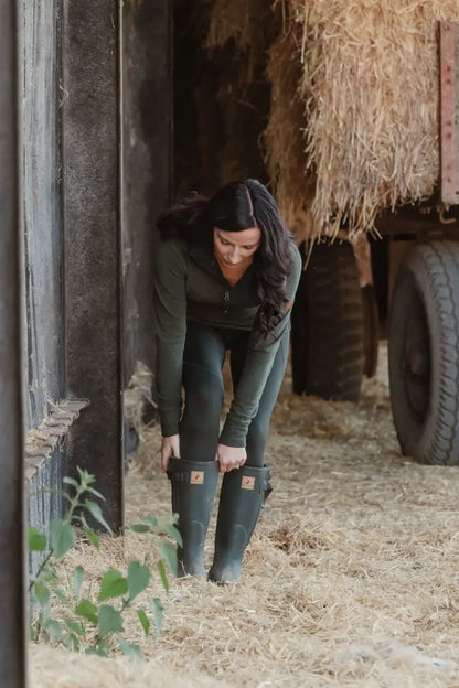 Woman adjusting green Forest Avon zip wellington boots perfect for outdoor adventures