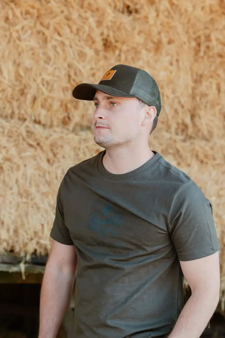 Man wearing a dark green country sport trucker hat, iconic trucker hat style
