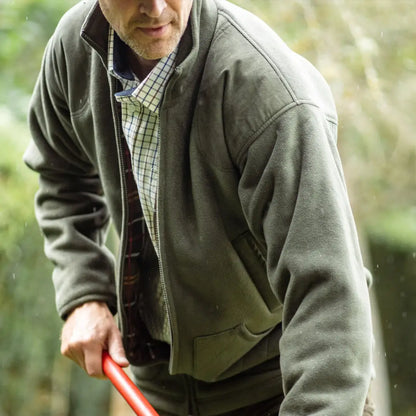 Man in a green New Forest Hawker jacket holding a red object, great for sport