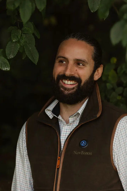 Smiling man in brown vest wearing a New Forest Heated Fleece Gilet outdoors