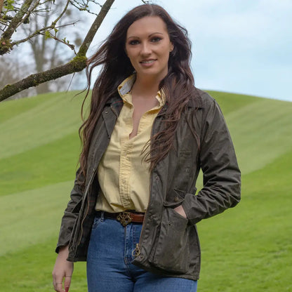 Woman in a green Antique Wax Jacket and yellow shirt enjoying the outdoors