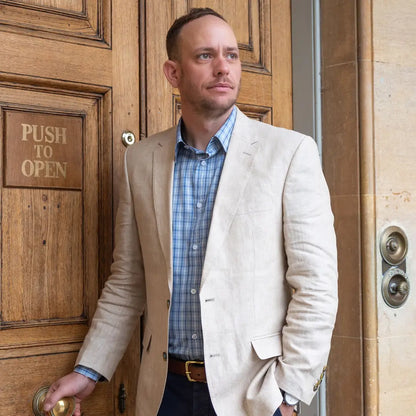 Man in light blazer and blue checked New Forest Premium Tattersall Shirt by wooden door