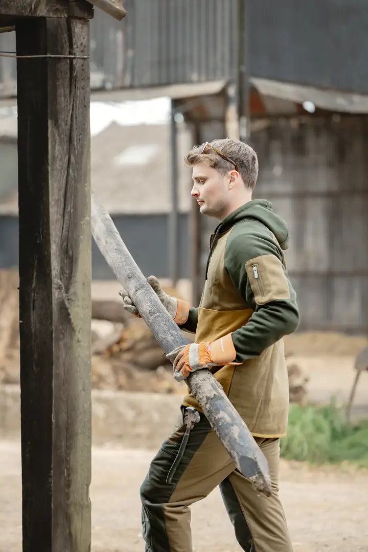Man with a large dirty metal blade wearing the New Forest Raptor Hoodie in forest raptor style