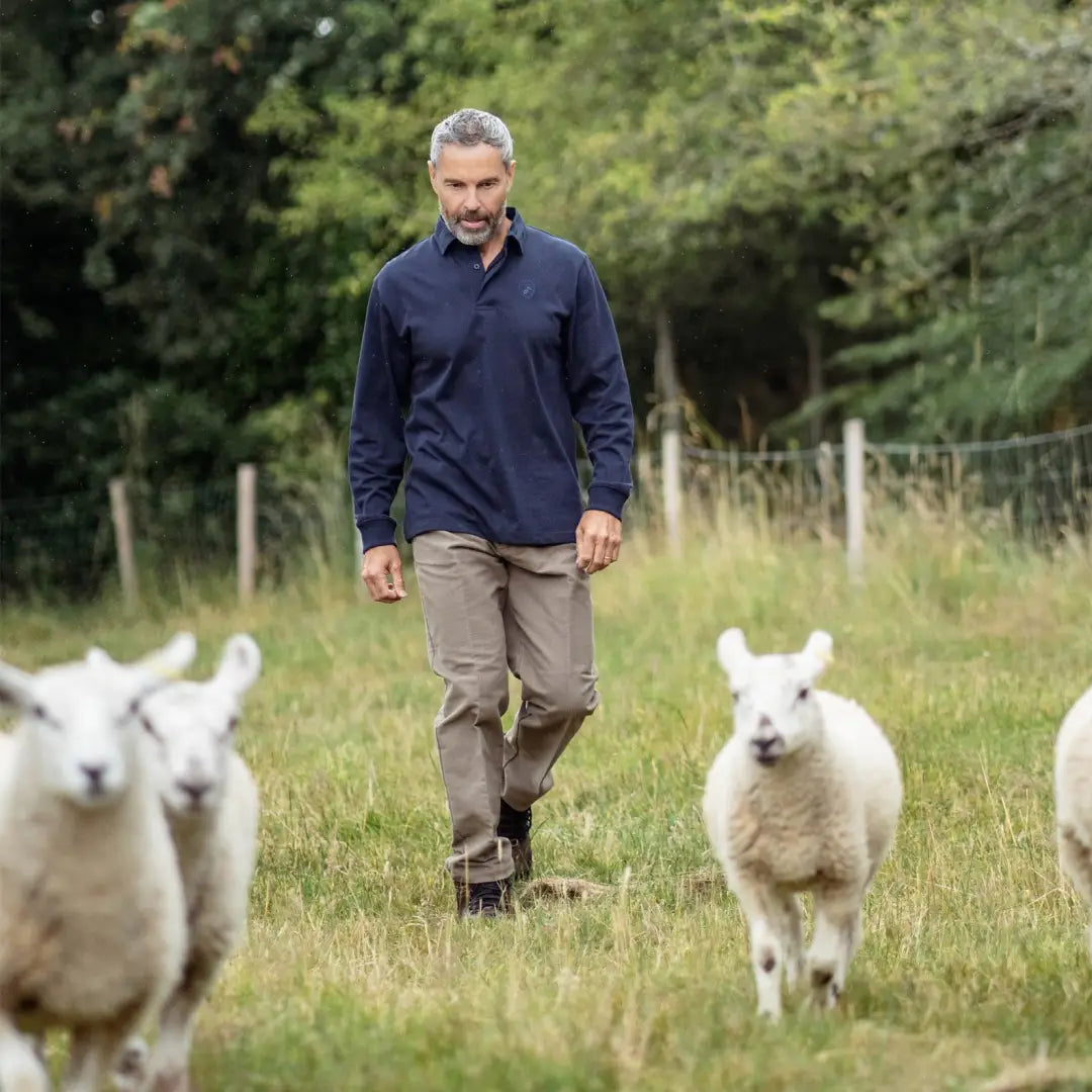 Man in a New Forest Rugby Shirt walking among sheep with a braided twill collar