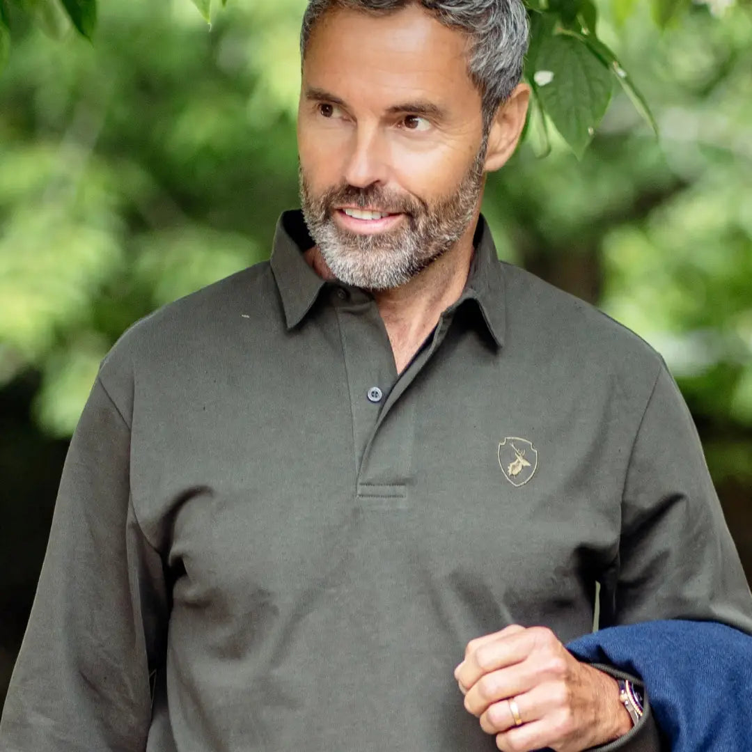 Middle-aged man with gray hair in a dark green Forest Rugby Shirt