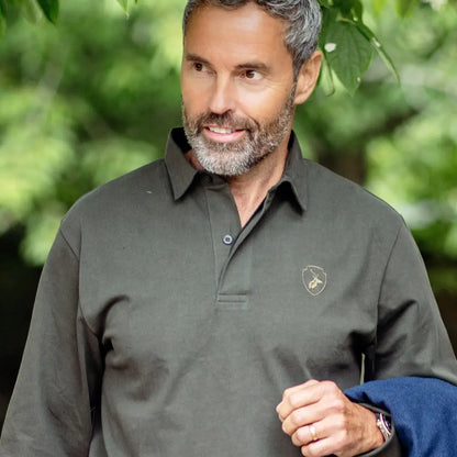 Middle-aged man with gray hair in a dark green Forest Rugby Shirt