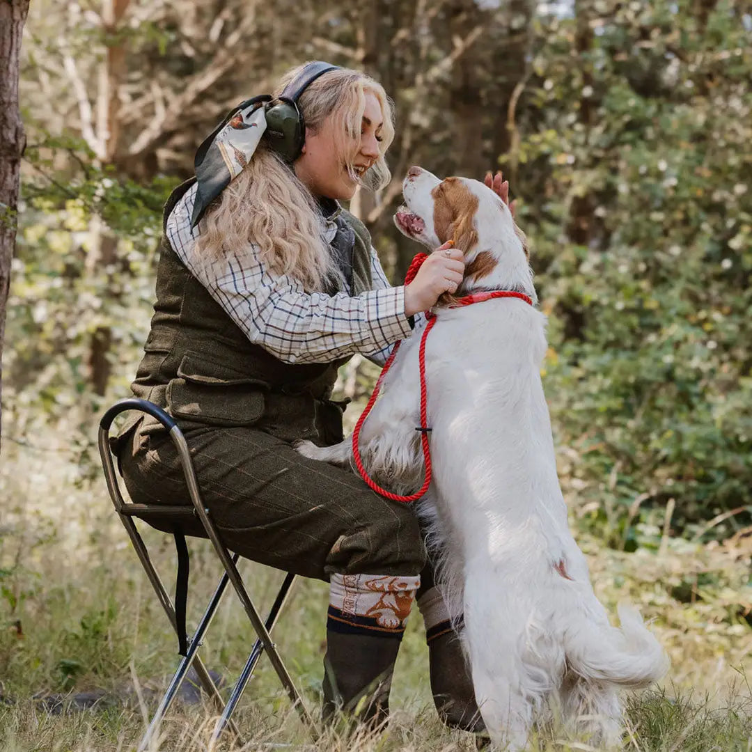 Woman in New Forest Tweed Breeks lounging with her affectionate white dog