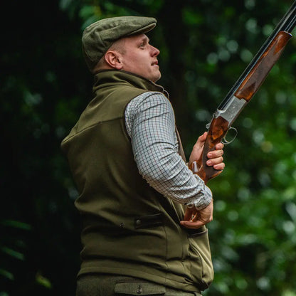 Man holding a shotgun, showcasing Seeland Wenlock Mens Waistcoat for hunting and outdoors